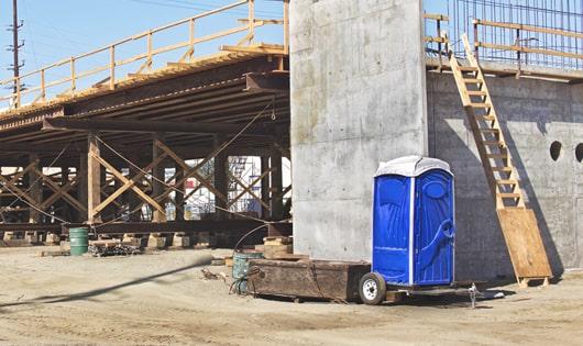 a lineup of sanitized portable toilets on a busy job site